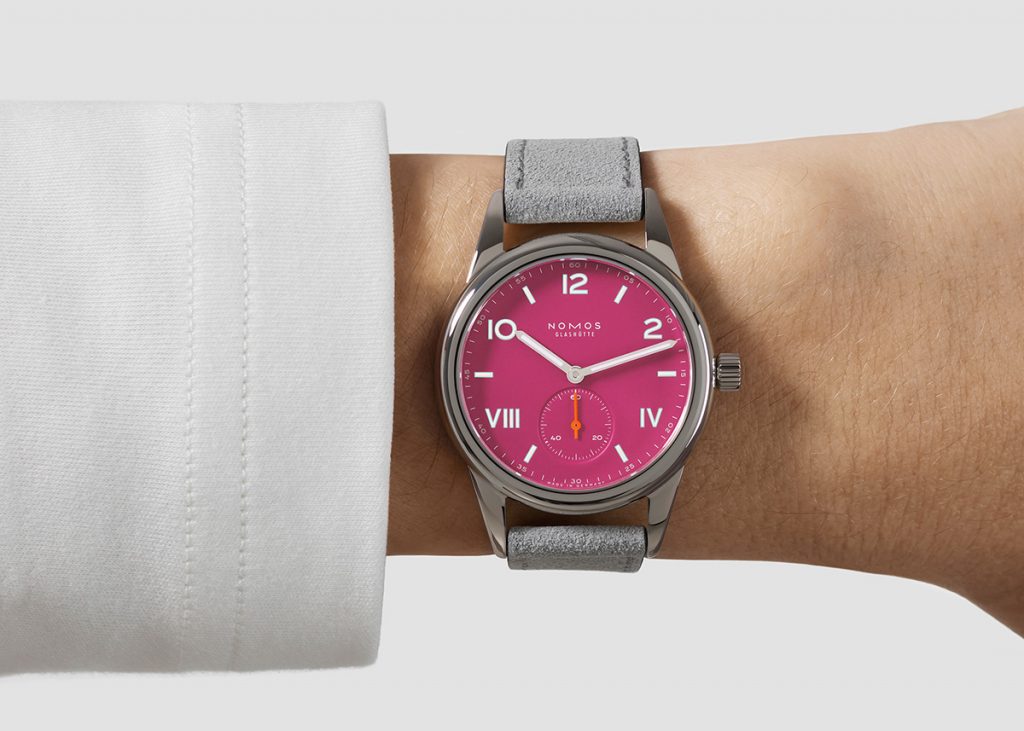 Steel cased watch with pink dial on a wrist