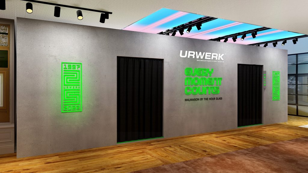 Grey wall with black curtained doorway, and neon green text Every Moment Counts