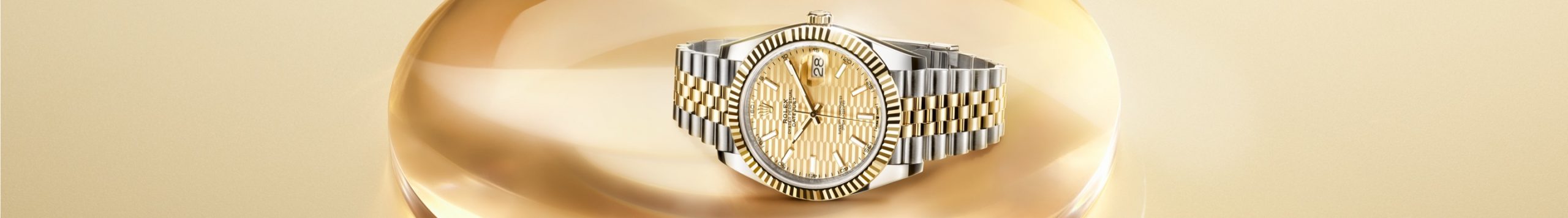 Rolex Datejust with champagne dial against gold background